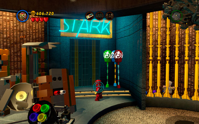The last bunch of balloons is placed under the STARK neon, next to golden cage with Stan Lee closed inside - House Party Protocol - Deadpool Bonus Missions: Collectables - LEGO Marvel Super Heroes - Game Guide and Walkthrough