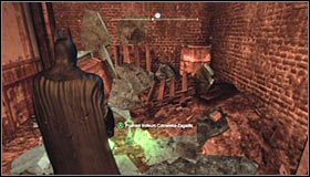 Jump over the small wall and look for a fragile wall fragment nearby the Trophy #1 - Batman trophies (17-25) - Industrial District - Batman: Arkham City - Game Guide and Walkthrough