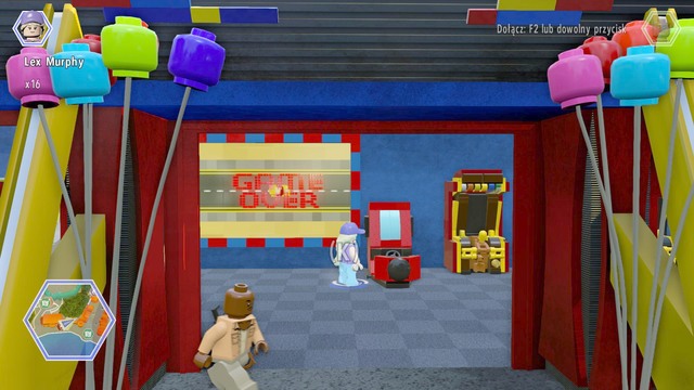 As Murphy, walk to the game zone and use the machine shown on the picture - Main Street - Jurassic World - secrets in free roam - LEGO Jurassic World - Game Guide and Walkthrough
