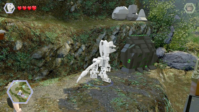 After reaching the shore, switch your character to dilophosaurus and destroy the rock that blocks access to the cave - Erics Hideout - Jurassic Park III - secrets in free roam - LEGO Jurassic World - Game Guide and Walkthrough