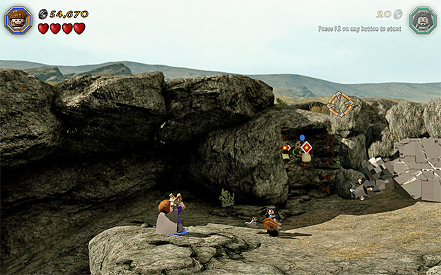 Switch to a character with slingshot now and start firing pebbles at the targets and try to bring about the situation, where above the above the target on the left, there appears a red circle, and a blue one above the one on the right - Stage 5 (The Troll Hoard) - Main Stages - Collectibles - LEGO The Hobbit - Game Guide and Walkthrough