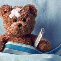 A teddy with a plaster and thermometer