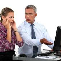 Man and woman discussing and pointing on a computer