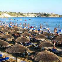 Beach crowded with people and sunshades