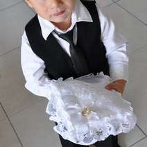 Boy holding a white lace cushion