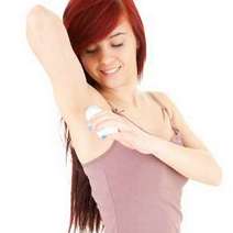 Woman applying deodorant in her armpits