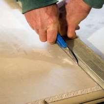 Hands cutting a board