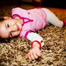 Girl lying on a shaggy brown carpet
