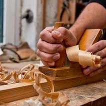 Person shaving a piece of wood