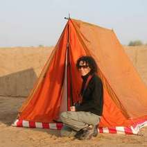 Woman posing in front of a tent in a desert