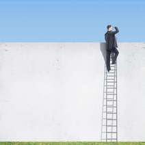  A man on the ladder atop of a white wall