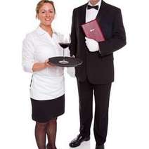  A waitress holding a glass of wine and a waiter