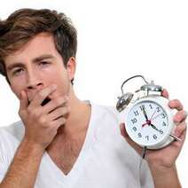  A yawning man holding an alarm clock
