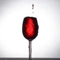 A glass of red wine being over filled
