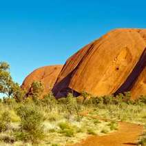  Grass and sandy road with huge rocks behind