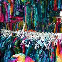  Hangers with dyed colorful dresses and T-shirts 