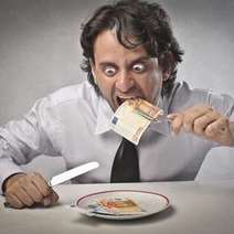  Man eating euro bank notes out of the plate