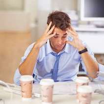  A man sitting over several cups of coffee