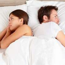  Couple in bed turned to each other with back