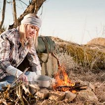  Woman camping and cooking on an open fire