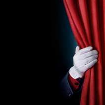 White glove holding a red curtain