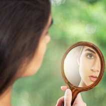  Woman's face in a small mirror