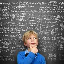 A boy thinking in front of chalkboard