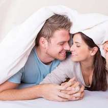  Man and woman kissing under blanket