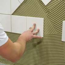  Tiles being glued on wall