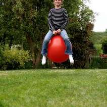  A boy bouncing on a ball