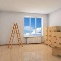An empty room with a ladder and boxes 