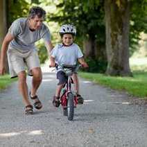  Dad teaching his kid how to ride a bike