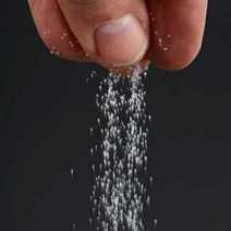 A hand adding a pinch of salt