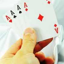 A hand holding four aces