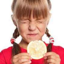  A girl making sour face when biting lemon