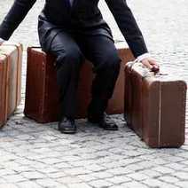A man sitting on packed suitcases