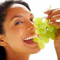 A woman eating grapes