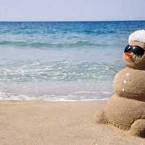 A snowman built of sand on a beach