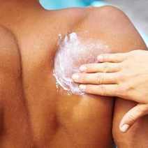  Suntan cream being spread on someone's back