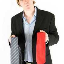  A man in a suit deciding between two ties