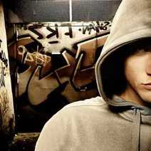 A boy in a hoody sweatshirt with graffiti behind