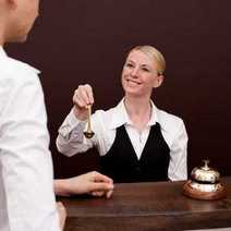 a guest receiving his room key at the hotel reception desk