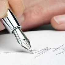 Hand with fountain pen signing a document