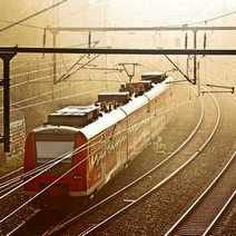 A misty view of a red electric train and railroads